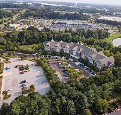 an aerial view of a building surrounded by trees and a parking lot