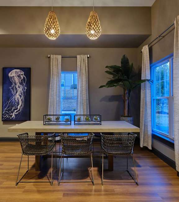 A dining room with a white table and green chairs.