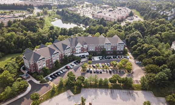 an aerial view of a large building surrounded by trees and a parking lot