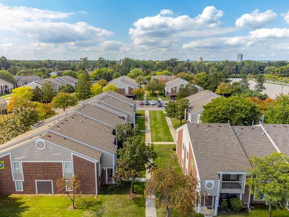 an aerial view of a neighborhood of houses with trees and a river