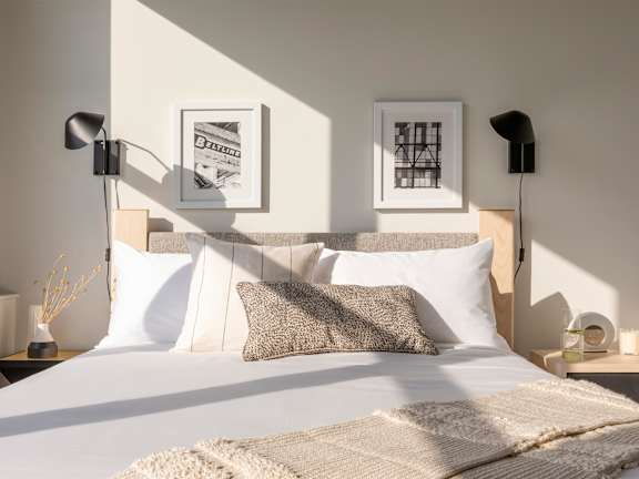 Bedroom with white comforter at Lofts at Centennial Yards, Georgia