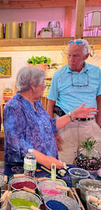 a group of people standing around a table filled with bowls and bowls of food
