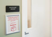Thumbnail 3 of 8 - a package room door with a sign on it and a window