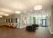 Thumbnail 2 of 8 - a large lobby with chairs and couches and a painting on the wall