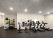 Thumbnail 4 of 8 - a gym with cardio equipment and weights in a room with white walls