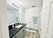 Thumbnail 7 of 8 - A bathroom with a sink, toilet, and shower.