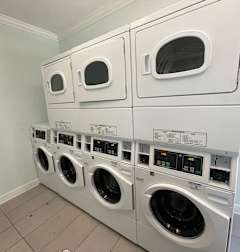 a row of washers and dryers in a laundry room