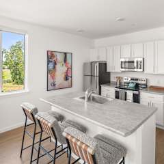 A kitchen with a bar area and a painting on the wall.