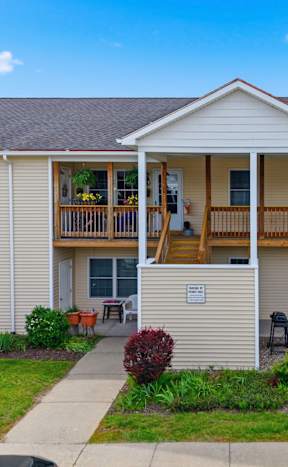 A two-story apartment building with a balcony on the second floor.