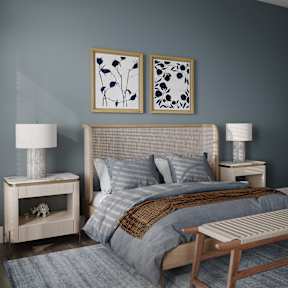 a bedroom with a bed and two paintings on the wall