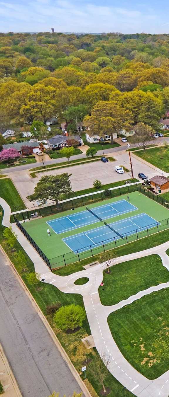 A park with a playground, tennis courts, and a basketball court.