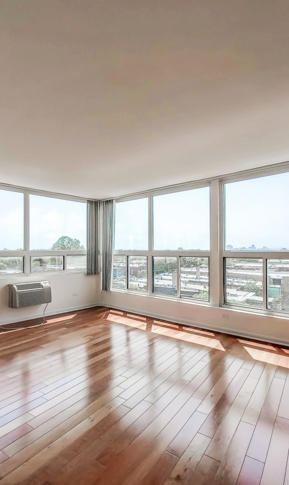 a bedroom with a large window and hardwood floors