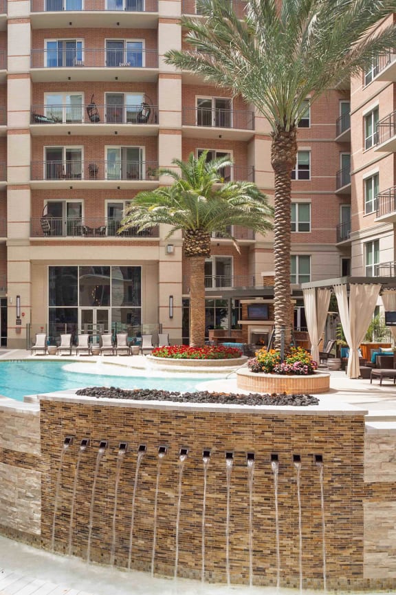 a large pool with palm trees in front of a building