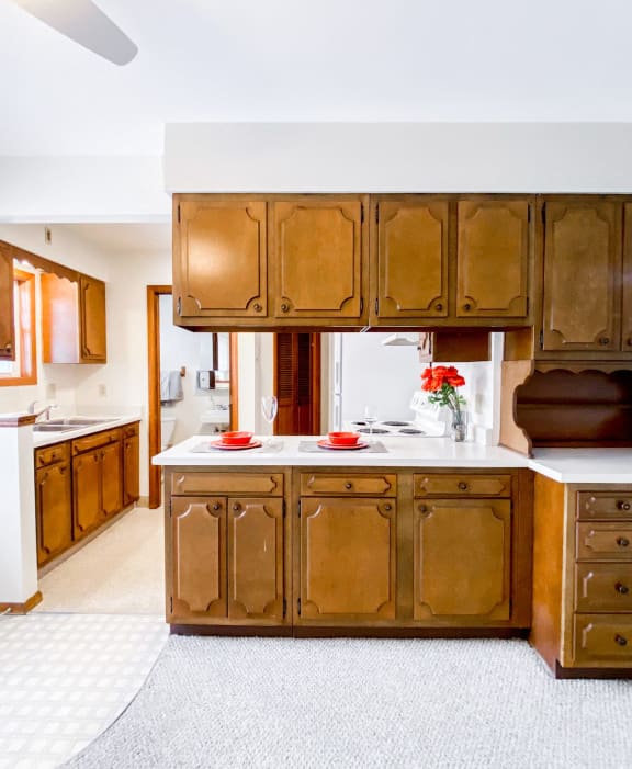 a kitchen with wooden cabinets and a white counter top