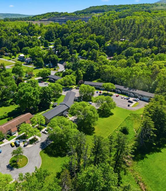 A bird's eye view of a residential area with a large green field and a building.