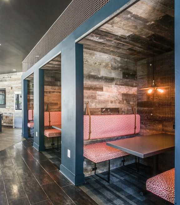A modern restaurant with a rustic touch, featuring a wooden table and benches.