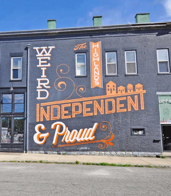 A building with the words "Weird Independent & Proud" painted on it.