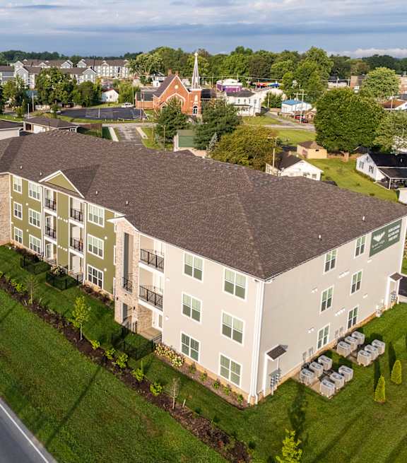 A large apartment complex with a parking lot in front.