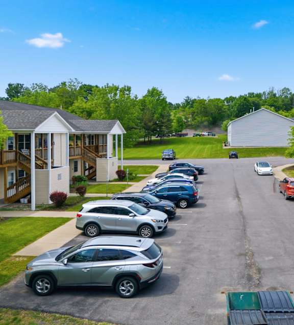A parking lot with cars and houses on both sides.