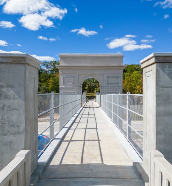 a bridge leading to a building with an arch