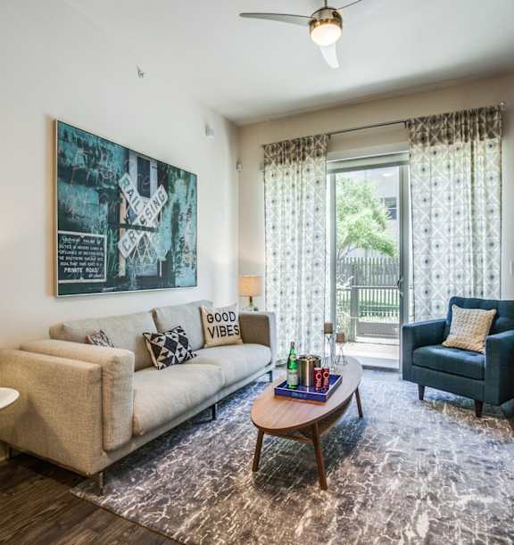 A living room with a couch, a chair, a table, and a painting on the wall.