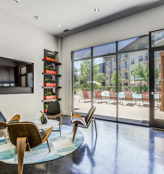 A room with a large window and a view of a pool and trees.