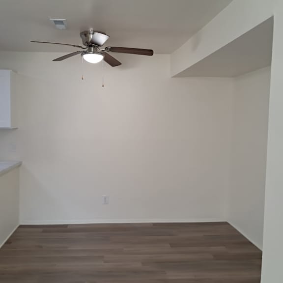 A room with a ceiling fan and a sink.