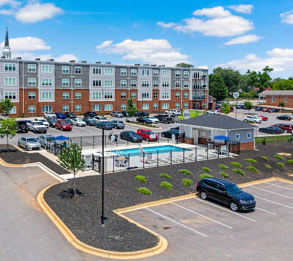 A parking lot with a pool and a building in the background.