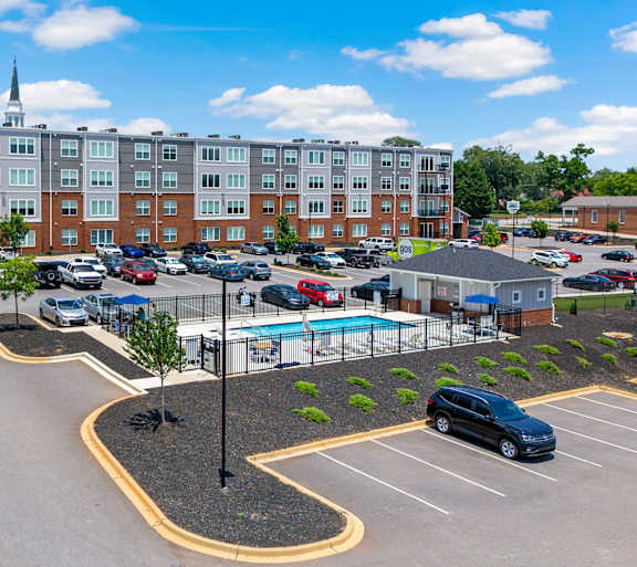 A parking lot with a pool and a building in the background.