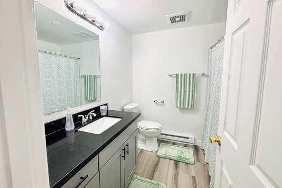 A bathroom with a sink, toilet, and shower.