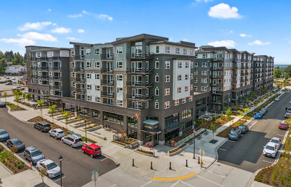 A large apartment building with a parking lot in front.
