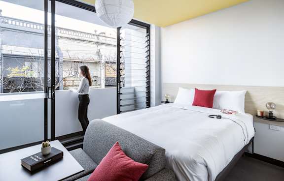 a living room with a green couch and a balcony