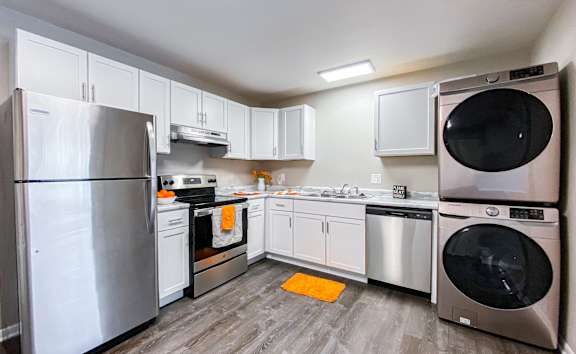 A modern kitchen with a stainless steel refrigerator and a dishwasher.