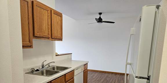 A kitchen with wooden cabinets and a white fridge.
