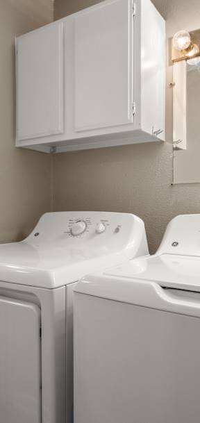A white washing machine and dryer in a laundry room.
