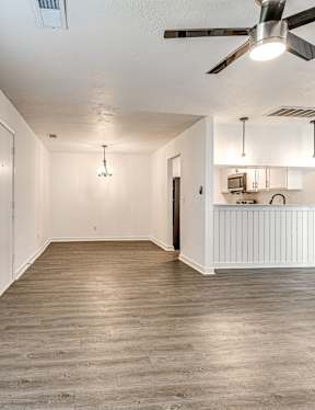 A room with a ceiling fan and light fixture.