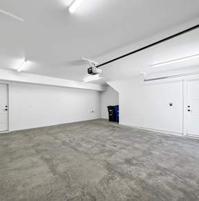 A large, empty room with white walls and a concrete floor at Matilda 235 Townhomes, Des Moines, IA.