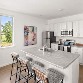 A kitchen with a bar area and a painting on the wall.