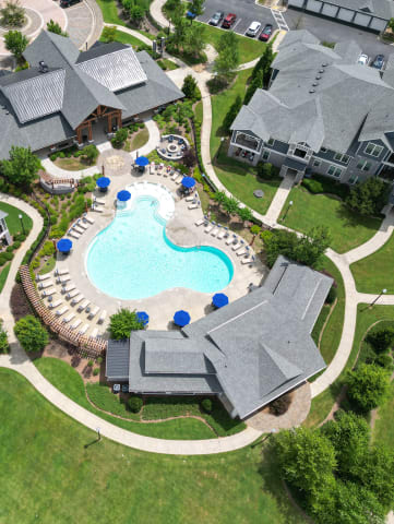 an aerial view of a large swimming pool in a neighborhood with houses