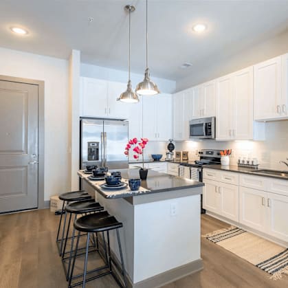 A kitchen with a bar area and a fridge.