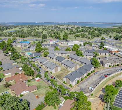 A bird's eye view of a residential area with houses and a parking lot.