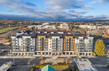 A large multi-story building with a parking lot in front.