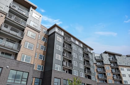 a large apartment building with a blue sky in the background
