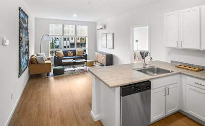 A modern kitchen with a dining area and a living room.