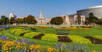 A beautiful garden with a white building in the background.