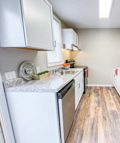 a renovated kitchen with stainless steel appliances and white cabinets
