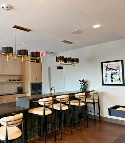 A modern kitchen with a bar area and a fridge on the left.