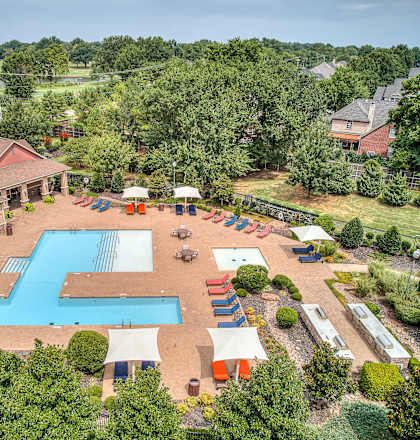 A large outdoor swimming pool surrounded by a patio area with a gazebo.
