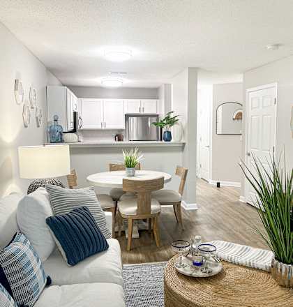 a living room with a couch and a table and a kitchen