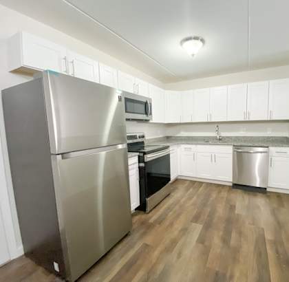 a kitchen with white cabinets and stainless steel appliances